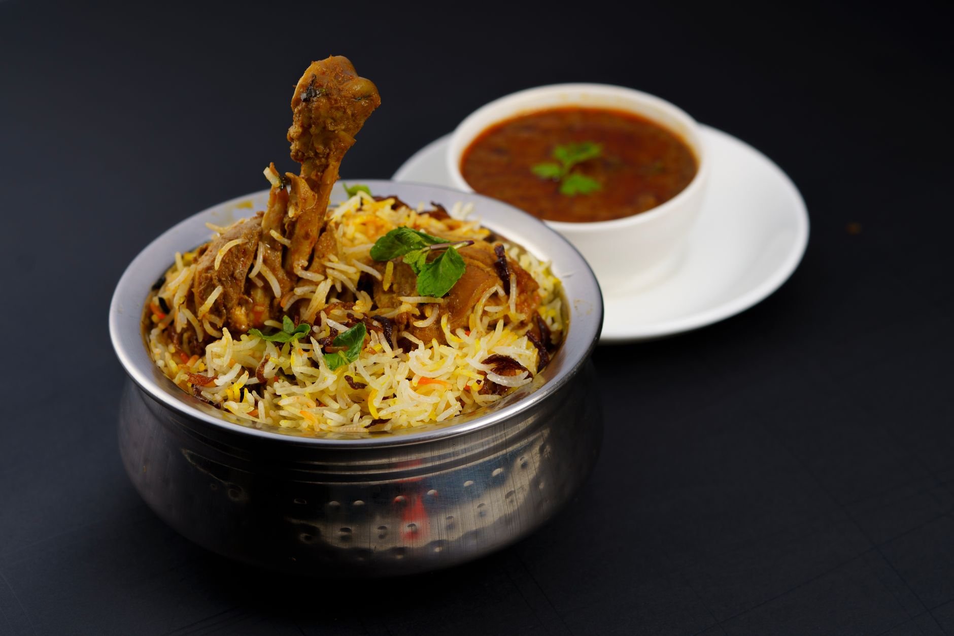 Flavourful chicken biryani served with spicy curry — a traditional Indian dish